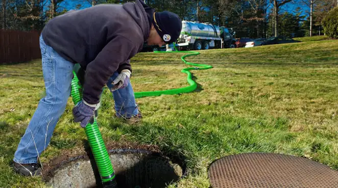 Service technician performing residential septic pumping and drainage maintenance in Manchester, NH